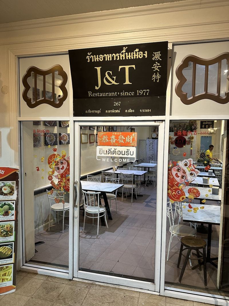 หน้าร้านเจแอนด์ที ป้ายดำตัวทอง ร้านอาหารพื้นเมือง J&T Restaurant since 1977 เหนือประตูกระจก